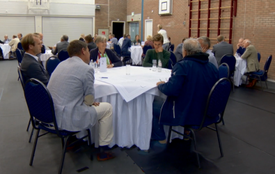 een groep mensen zittend aan een tafel