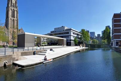 Uitzicht op een rustige waterweg in Rotterdam met moderne gebouwen aan beide zijden